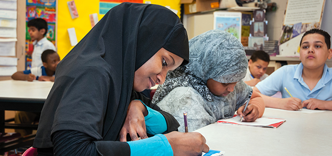 Cleveland students with hijabs writing at a table