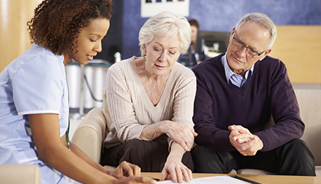 Image of older couple looking at papers with a health professional